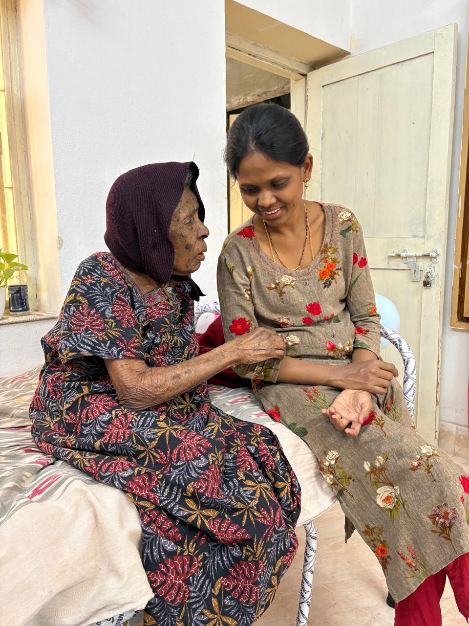 An elderly resident sharing a warm moment with her caregiver
